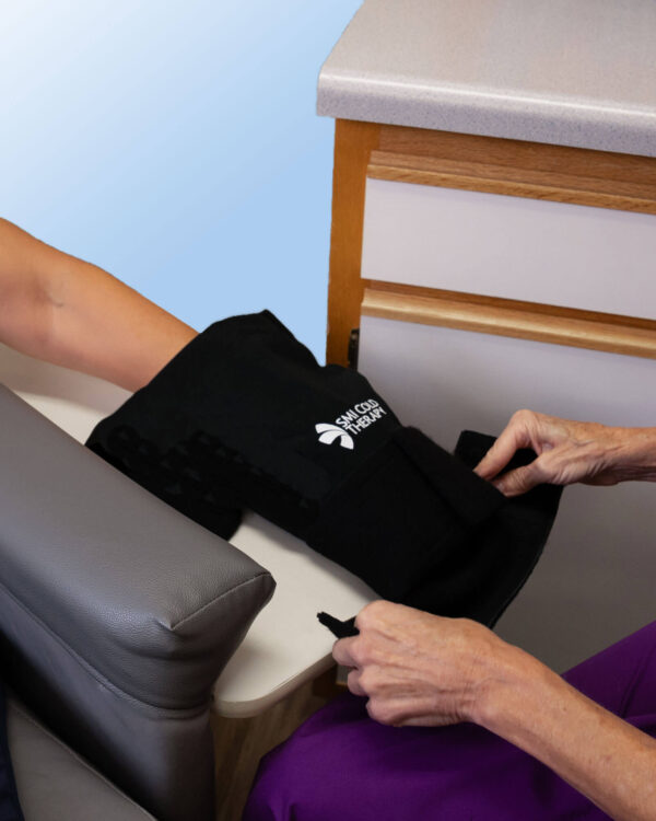 Nurse applying an SMI Chemo Infusion Cooling Wrap to the hand